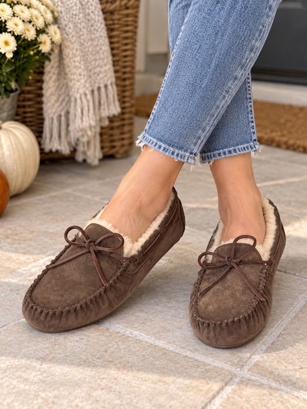 UGG Dakota moccasin slippers shearling lining and leather lace bows.